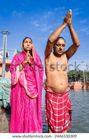 devotee couple praying after bathing in holy river water at morning from flat angle Royalty-Free Stock Photo #2446530309