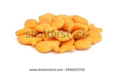 A scaterring of yellow goldfish crackers in glass bowl on white Royalty-Free Stock Photo #2446545743
