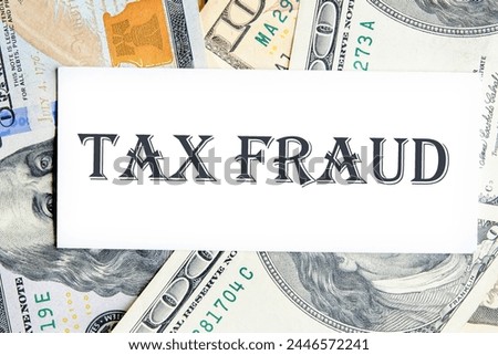 TAX FRAUD on a white business card against the background of money, a business concept