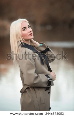 Portrait of a young beautiful blonde girl in the spring near the river.