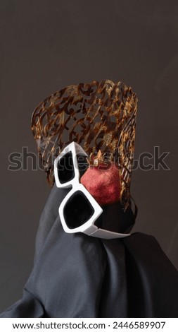 Spanish comb with sunglasses and dried pomegranate on black background