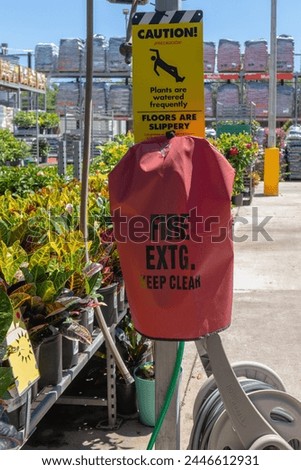 vertical view of slippery floor cautionary sign and fire extinguisher cover in garden center