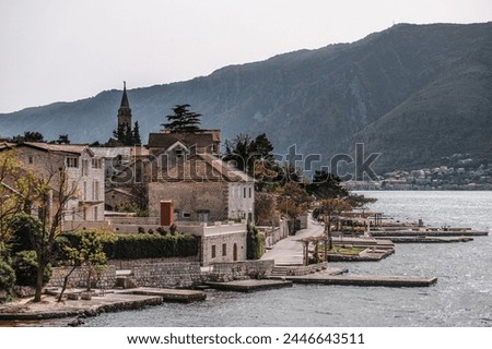 Panoramic landscape with old church in Kotor, Montenegro.Harbor and boats on a sunny day in Boka Kotorska bay, Montenegro, Europe Royalty-Free Stock Photo #2446643511