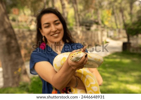 Woman holding a snake. Albino burmese python.
Python molurus bivittatus.