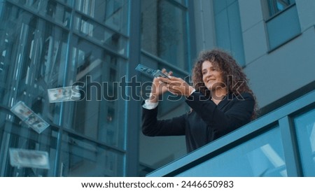 Caucasian rich business lady successful woman businesswoman entrepreneur happy young girl throwing dollars banknotes in air money rain financial currency cash wealth outdoors office balcony in city