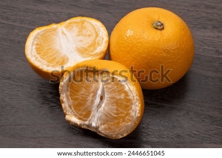 Japanese citrus hassaku on wood grain background Royalty-Free Stock Photo #2446651045