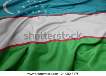 waving colorful national flag of uzbekistan. macro shot