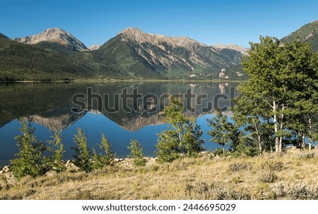 Mount Hope and Twin Peaks rise above the reflection on Twin Lakes in Central Colorado which is located within the San Isabel National Forest. 
