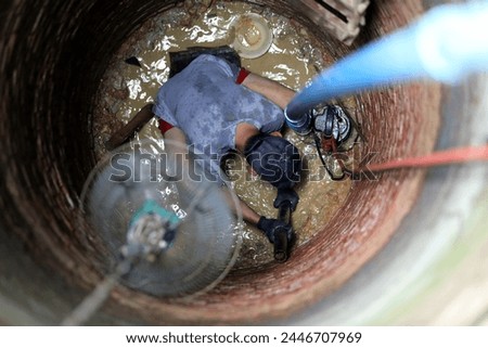 Top view of The man-worker is working on clearing and digging the artesian well or draw-well in Thailand at home to find water for use in the summer. In times of drought. Royalty-Free Stock Photo #2446707969