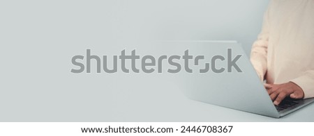 Young businessman hand typing on laptop computer while working in white modern office room for business or technology background, Contact and communication in the organization.