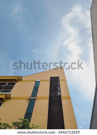 A photo of the building taken from below to show the clear blue sky with a slight cloud cover. Royalty-Free Stock Photo #2446712829
