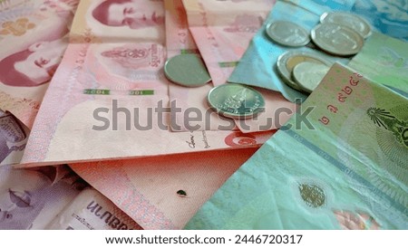 Close-up of a pile of twenty baht, fifty baht, one hundred, five hundred and one thousand Thai baht (THB) notes of Thailand. high-resolution background images. Royalty-Free Stock Photo #2446720317