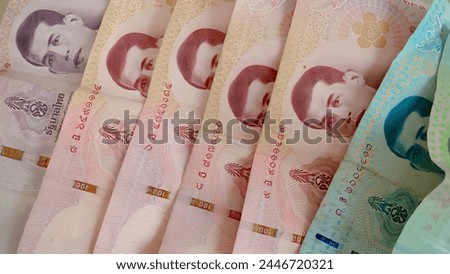 Close-up of a pile of twenty baht, fifty baht, one hundred, five hundred and one thousand Thai baht (THB) notes of Thailand. high-resolution background images. Royalty-Free Stock Photo #2446720321