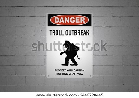 A Danger sign on a white brick wall warning about trolls.