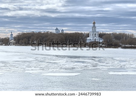 View of the Yuryev Monastery from the opposite bank of the Volkhov River. Ice drift on the Volkhov River on a clear spring day. Royalty-Free Stock Photo #2446739983