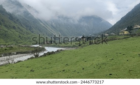 This picture is with a flowing river and showing the shelters of the villagers. And clouds are also making there way in to this picture.