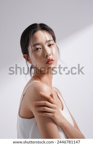 Beauty image of a young Korean woman photographed against a background of light and shadow