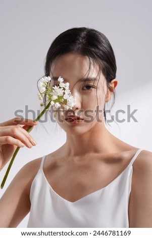 Beauty image of a young Korean woman photographed against a background of light and shadow