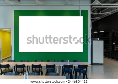 Mockup horizontal blank billboard with green frame on the wall at canteen, table and chair without people, lighting on ceiling, empty space for insert advertisement, graphic
