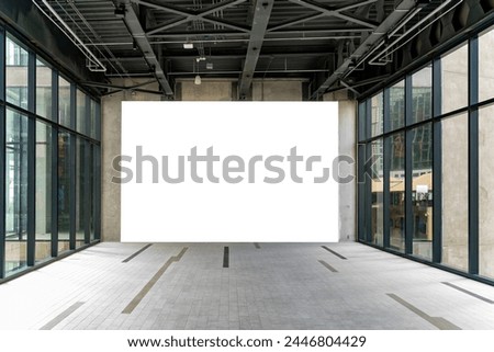 Mockup large blank billboard on the wall of empty room in building, glass windows with frame see another building, Empty space for insert advertisement, announcement or special promotion