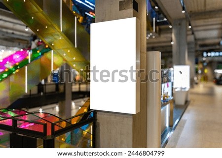 Mockup Blank lightbox advertising on the pole near showcase jewelry products and escalator in shopping mall, Empty space for insert media advertisement, discount, special price and promotion