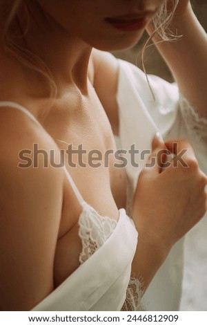 She is indoors and wearing an ivory bridal gown with lace and embellishments, including a bridal veil. The focus is on the brides attire and fashion accessories as she takes the photo.