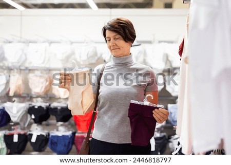 Elderly woman chooses panties in store