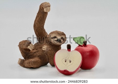 miniature toy of a sloth with red apples
