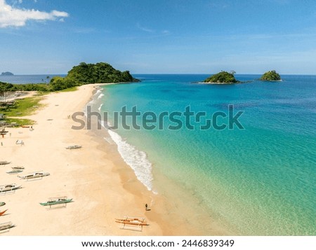 Boats over the sands with ocean waves. Nacpan Beach. El Nido, Philippines. Royalty-Free Stock Photo #2446839349