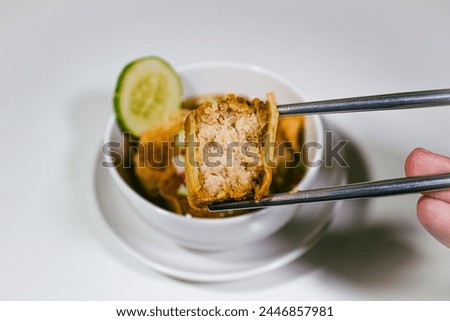 Asian food called gohyong, with fresh vinegar sauce, and chicken meat chopped then chopped with chopsticks with half of the part already eaten