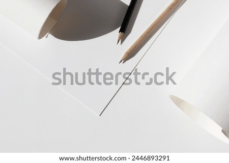 Design Studio Mockup. Sheets of Paper, Graphite Crayons, Paper Rolls Flatlay on Workplace Desk. Architectural Concept Showcase Mockup.	