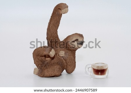 miniature figurine of a sloth with a cup of coffee