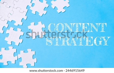 A jigsaw puzzle with the word content strategy written on it. The puzzle pieces are scattered across the image, creating a sense of disarray and complexity