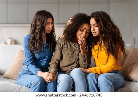 A group of caring multiracial friends shows concern for one crying woman, highlighting close bonds and empathy among them Royalty-Free Stock Photo #2446918743