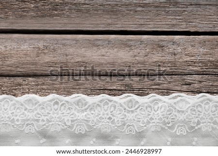 White lace on wooden table, top view. Space for text Royalty-Free Stock Photo #2446928997