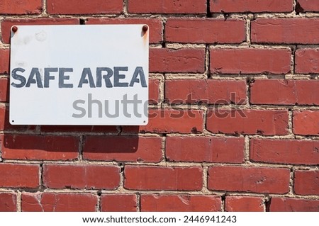 Sign on a brick wall that says Safe Area Royalty-Free Stock Photo #2446941243