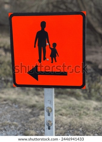 Temporary road sign showing silhouette of pedestrians an adult and a child The walkway is temporarily moved in the direction of the arrow. Perfect backdrop for pictures about e.g traffic GoranOfSweden