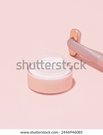 Pink jar of skincare cream on pink background