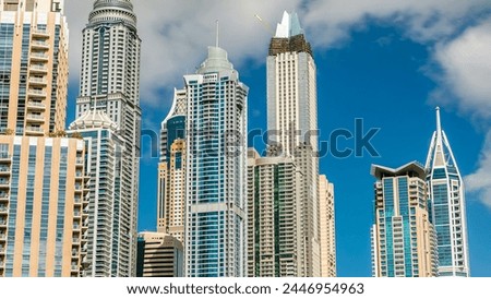 Luxurious Residence towers Buildings timelapse in Dubai Marina, UAE. Close up view with blue cloudy sky Royalty-Free Stock Photo #2446954963