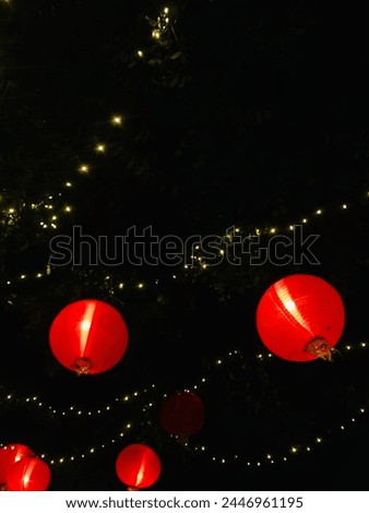 Chinese lanterns surrounded by little lamps like fireflies Royalty-Free Stock Photo #2446961195