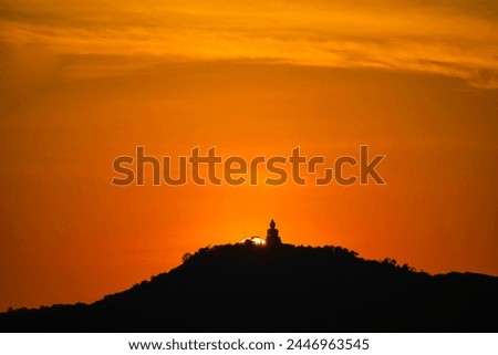 Amazing red sky in sunset at Phuket big Buddha. 
Phuket big Buddha in circle of the sun in red sky.
The beauty of the statue fits perfectly with the charming nature.
