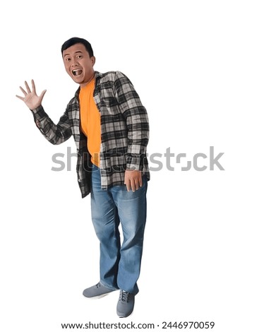 Happy asian man pop out for greeting and say hi.  Asian man standing dan say hello with waving hand. The expression of an Indonesian man waving his hand to say hello. Happy indonesian man.  Royalty-Free Stock Photo #2446970059