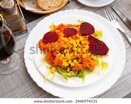 Appetizing light vegetable salad made from corn, sliced beetroot, bell pepper, grated carrots and onions