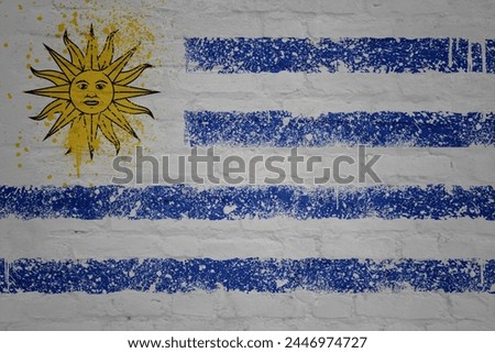 colorful painted big national flag of uruguay on a massive old brick wall