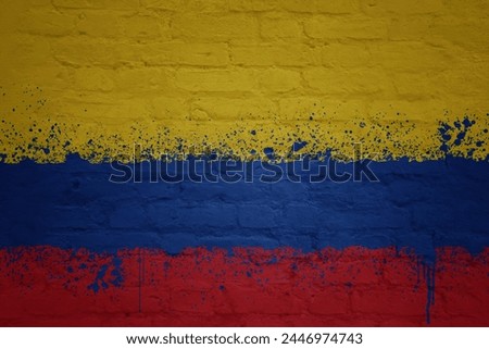 colorful painted big national flag of colombia on a massive old brick wall