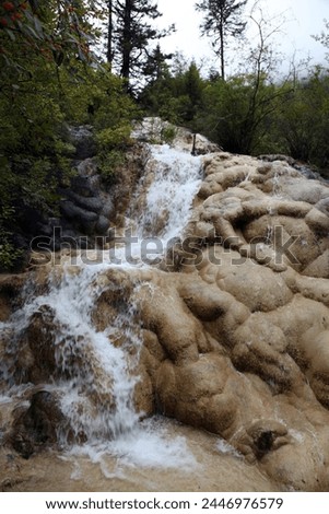 Exterior photo view of a waterfalls river over rocks in the mountains with pine trees and rivers in the chinese landscape panoramawith hills and humid woods