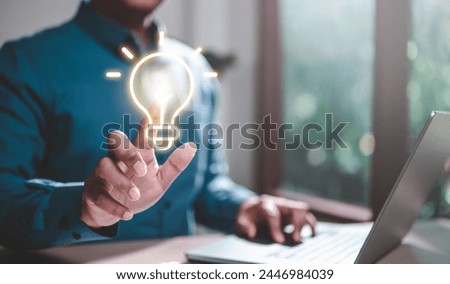 intelligence, genius, brain, brainstorm, ideas, imagination, insight, intellectual, invention, thinking. A man is holding a light bulb on a laptop. Concept of innovation and creativity. Royalty-Free Stock Photo #2446984039