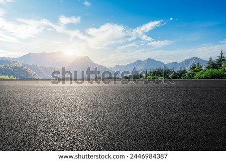 Asphalt road and green forest with mountain nature landscape under blue sky