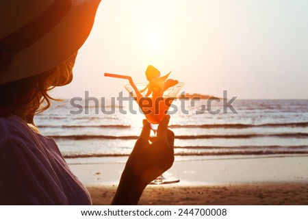 woman with cocktail on the beach