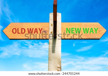 Wooden signpost with two opposite arrows over clear blue sky, Old Way and New Way signs, Life change conceptual image